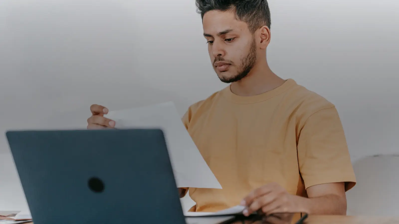 Indépendant vérifiant une facture devant son ordinateur