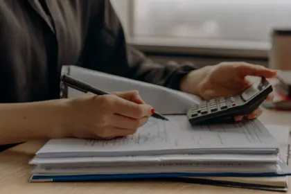Calcul de charges avec une calculatrice sur une pile de documents