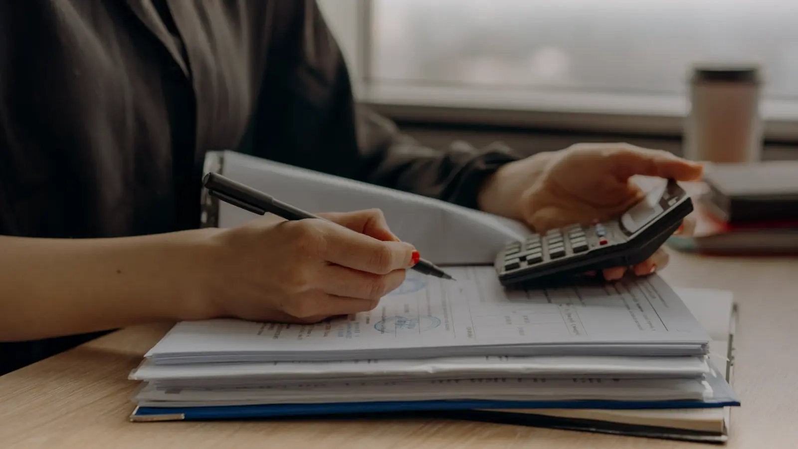 Calcul de charges avec une calculatrice sur une pile de documents