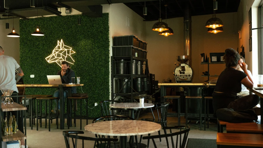 Espace de coworking avec comptoir café et postes de travail