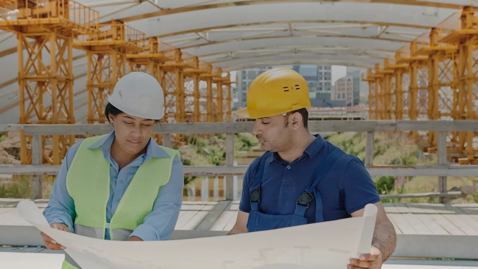 Deux professionnels du chantier examinent un plan de bâtiment
