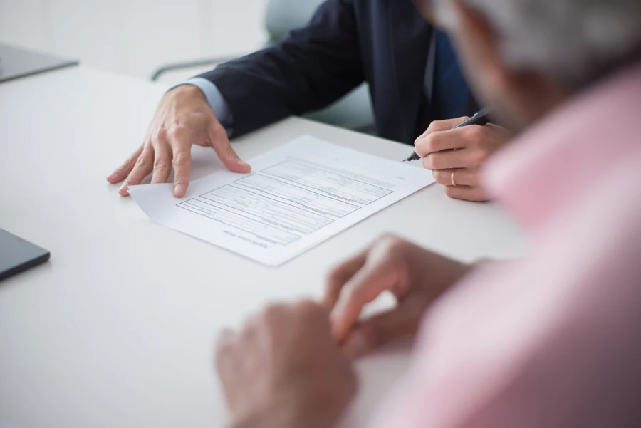 Signature d'un contrat sur une table de réunion entre un consultant et son interlocuteur